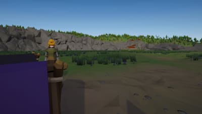 A villager looks across a wide meadow towards a distant monastery with red roofs, below rocky hills